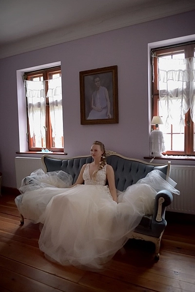 Panna Młoda w obszernej sukni ślubnej na zabytkowej sofie