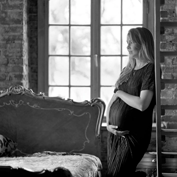 Modelka w ciąży oparta o drabinę w sypialni Pałacu
