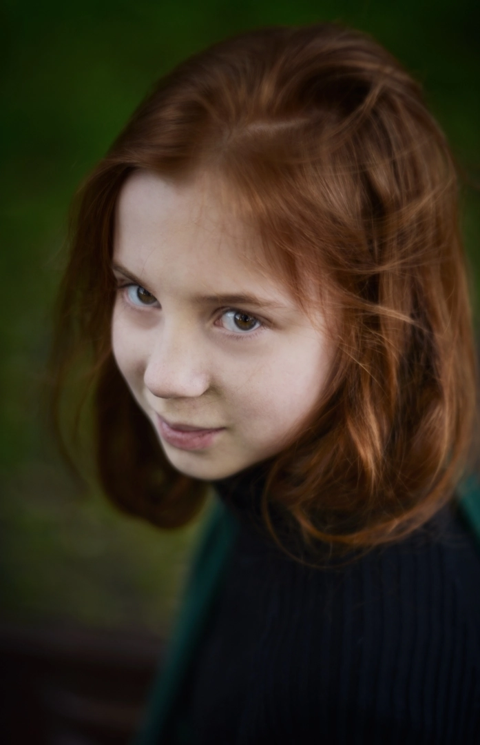 Portret dziewczynki o rudych włosach w zielonym golfie